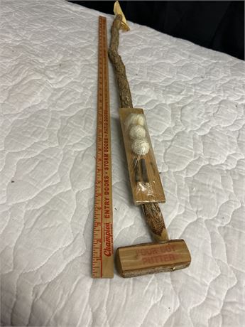 Hand made wooden putter with wooden tees and three Walnuts as golf balls