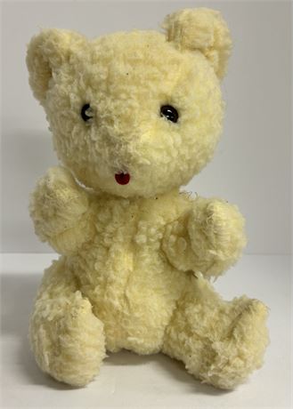 Vintage teddy bear with baby rattle inside