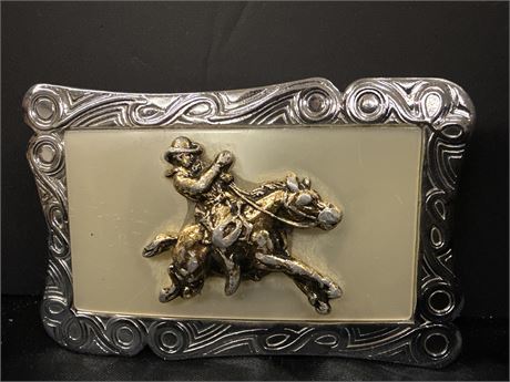 Western belt buckle cowboy on a bronc