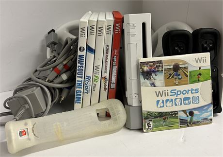 Wii console with 2 controllers and three steering wheels and six games.